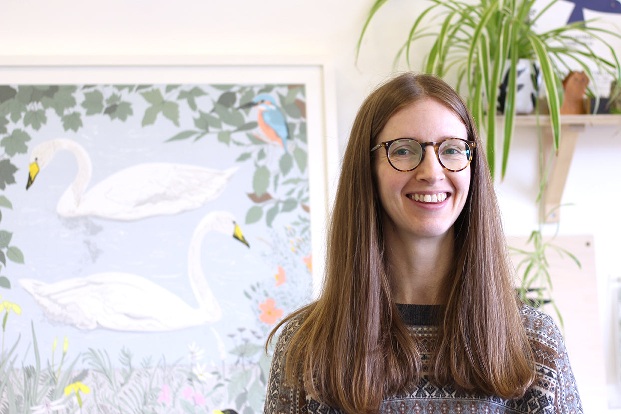 Susie Wright smiling in front of her artwork