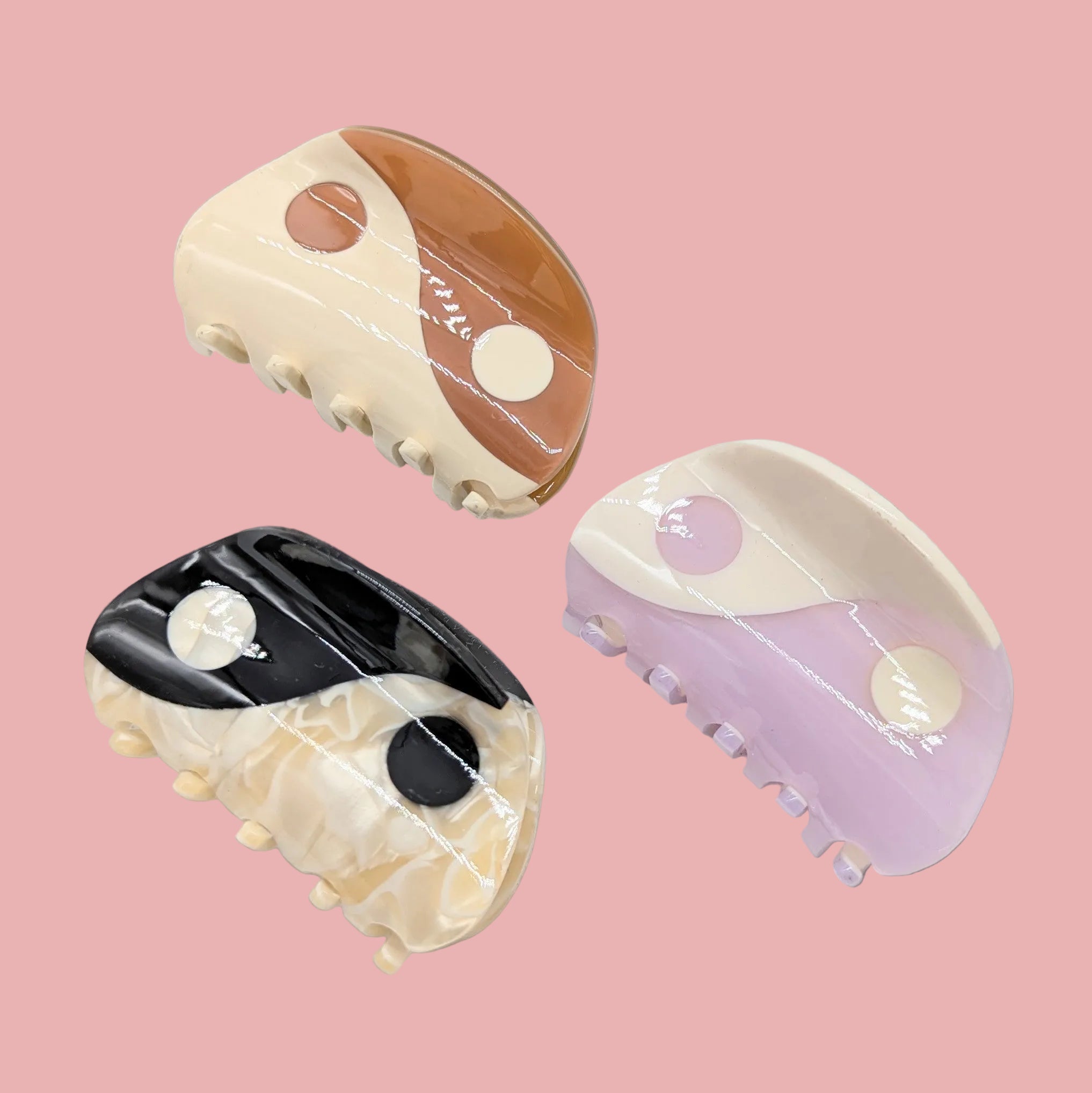 Three decorative hair clips with marble-like patterns on a white background