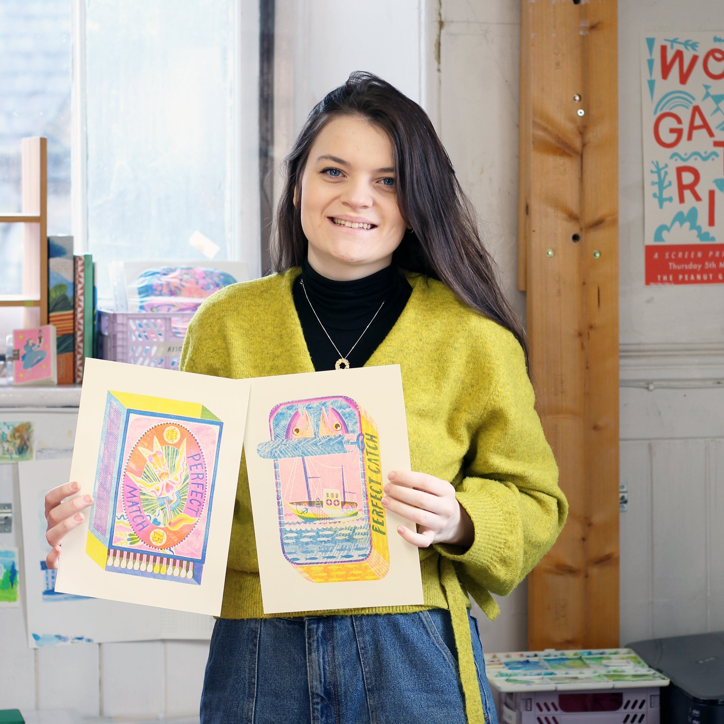 Rebecca Sheerin holding two of her riso prints