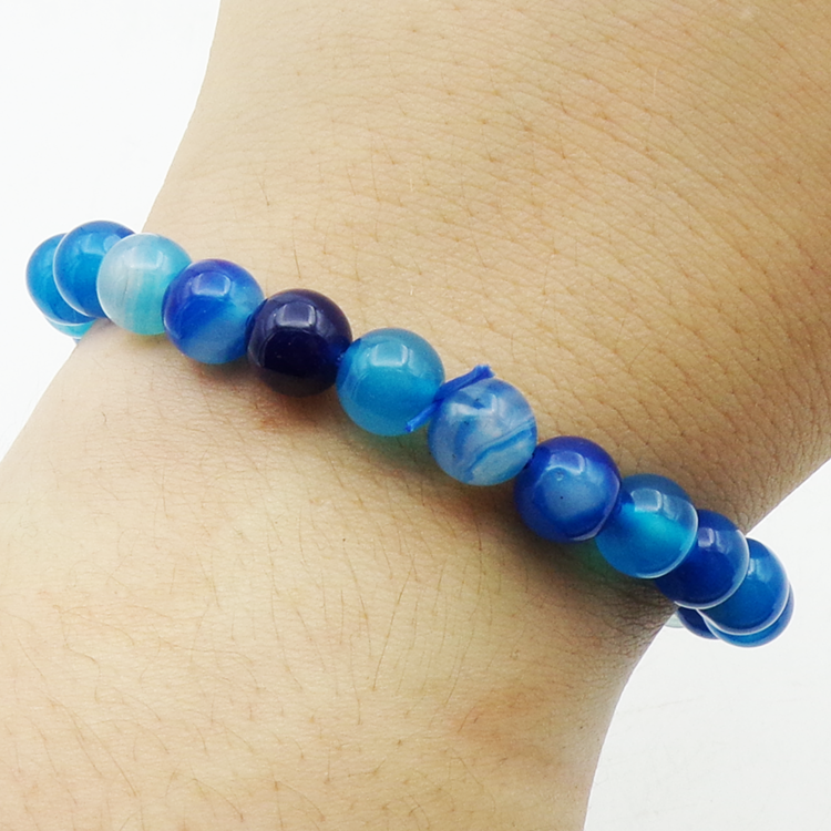 Blue Agate beaded bracelet on a wrist against a white background
