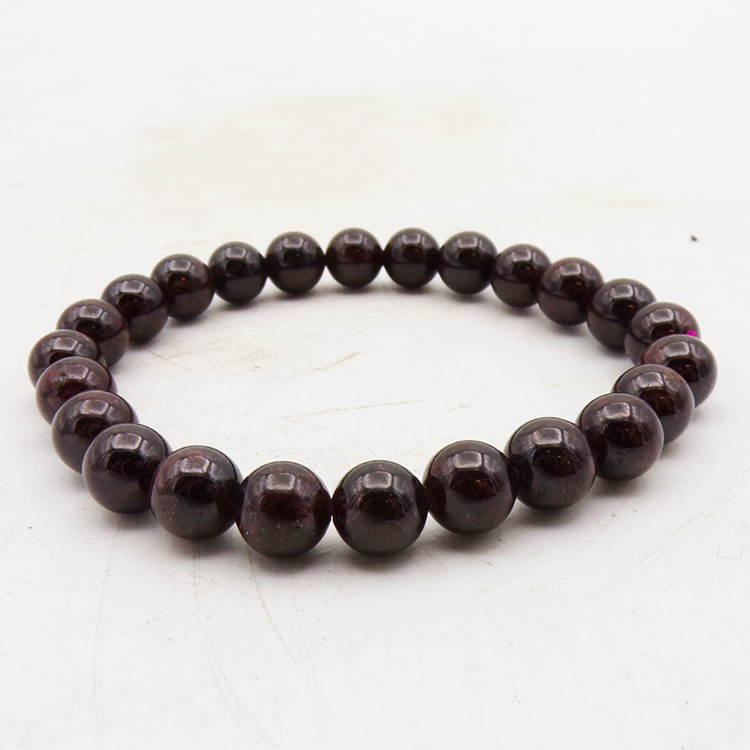 Deep glossy red-magenta beaded bracelet on a white background