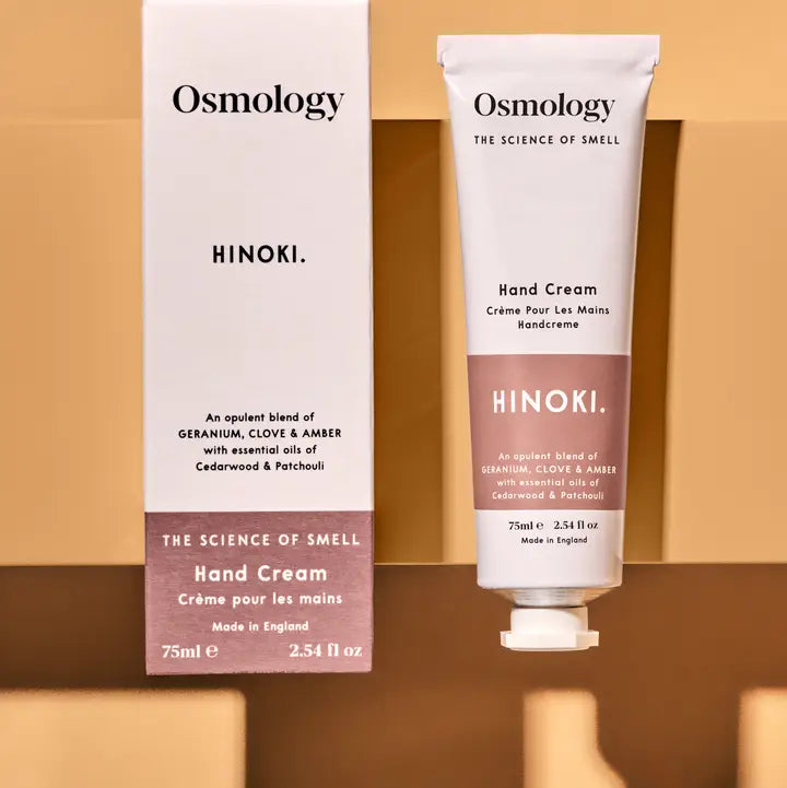 Osmology Hinoki hand cream and packaging on a beige background
