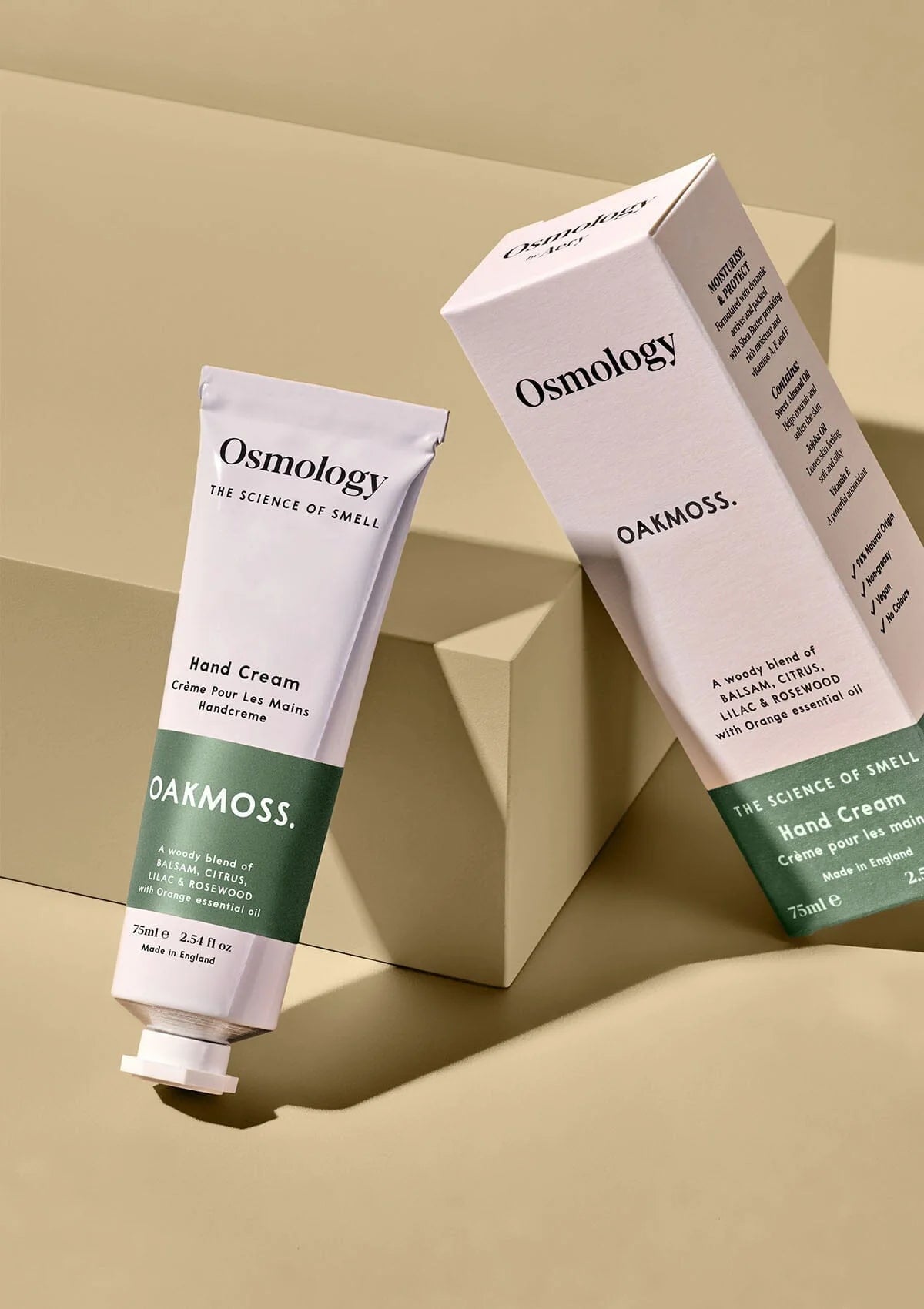 Osmology Oakmoss hand cream tube and packaging on a beige background