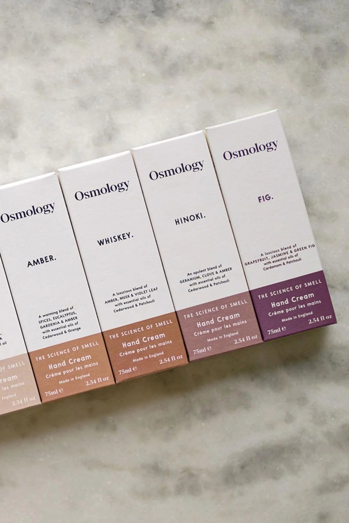 Osmology hand cream boxes on a gray surface