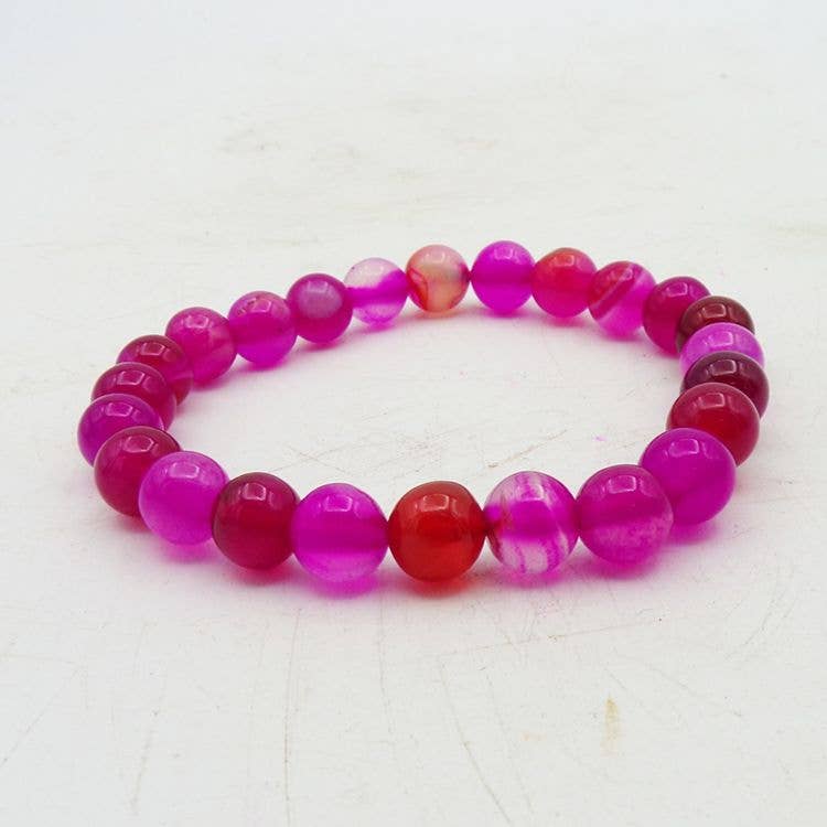 Pink Agate beaded bracelet with pink and red beads on a white background