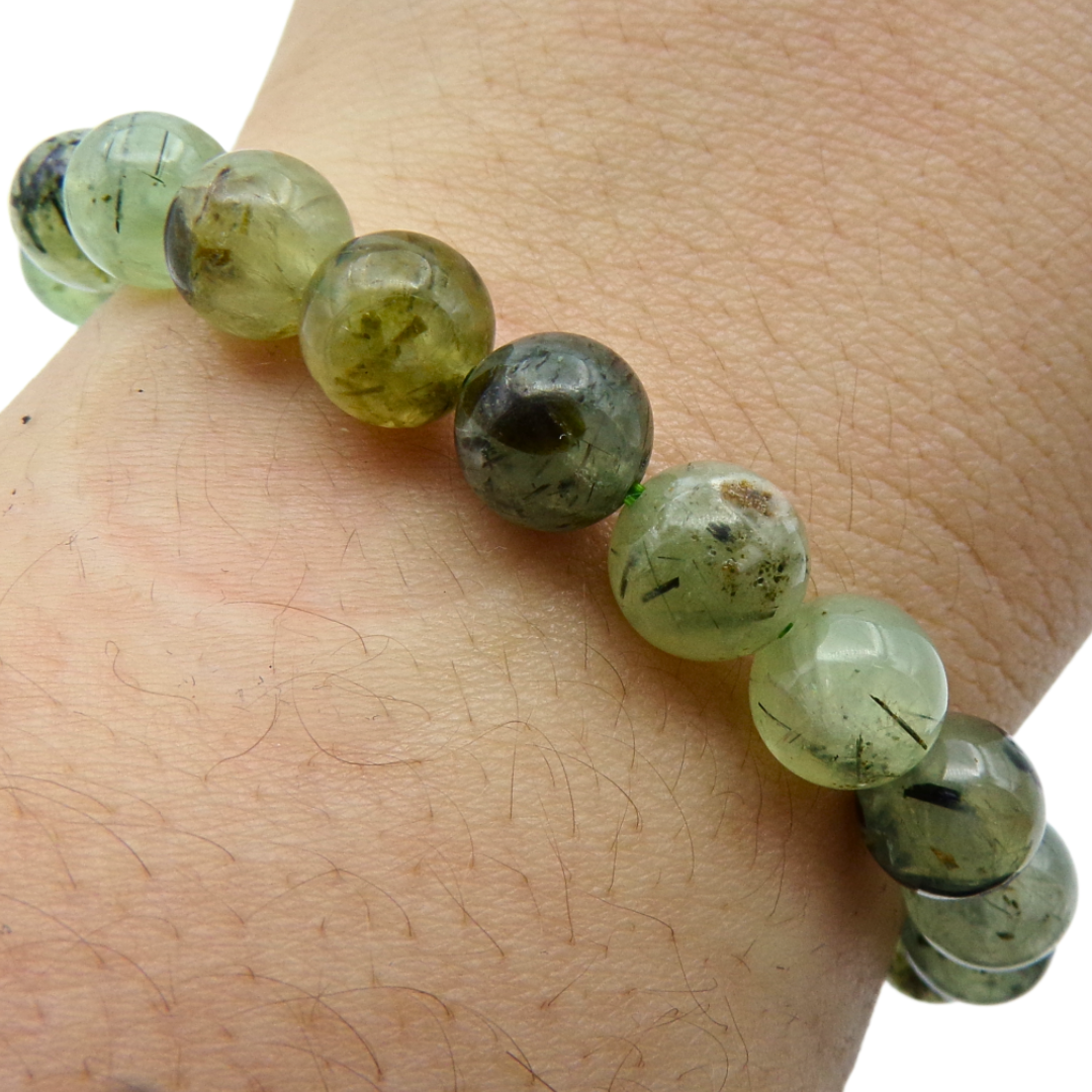 Prehnite Green beaded bracelet on a wrist with a plain background