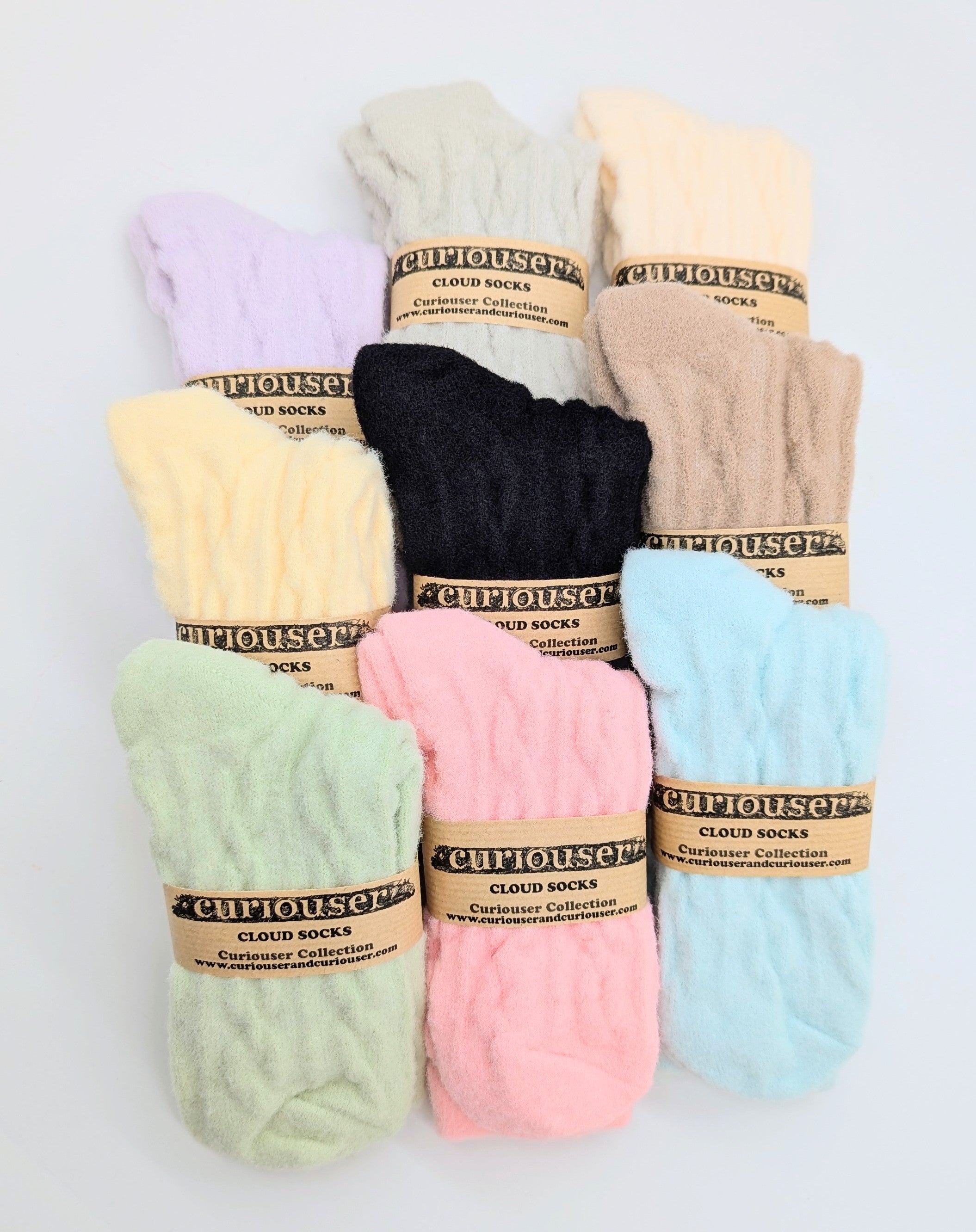 Set of colorful socks with 'Curiouser' branding on a light gray background