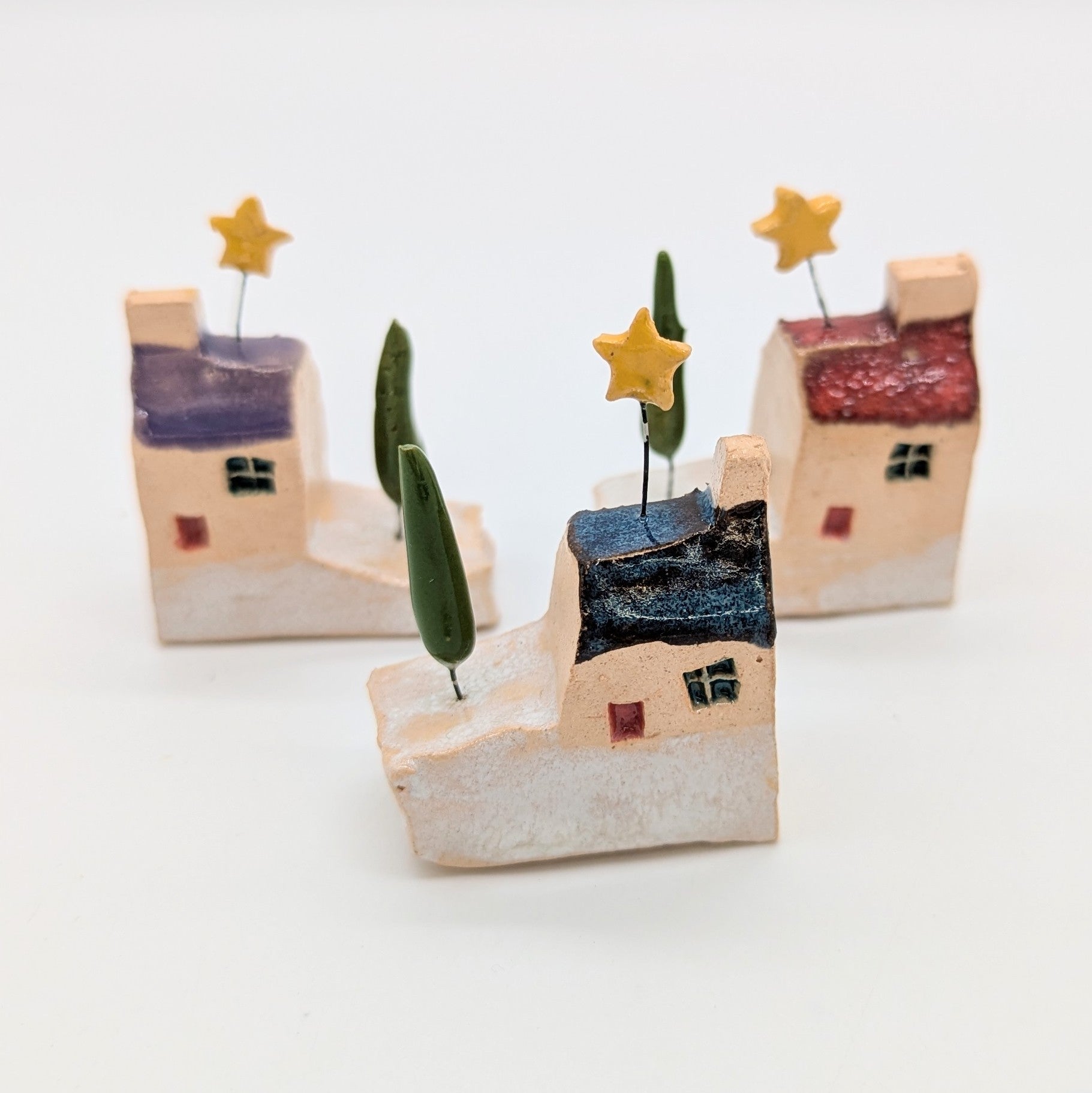 Small decorative houses with trees and stars on a white background